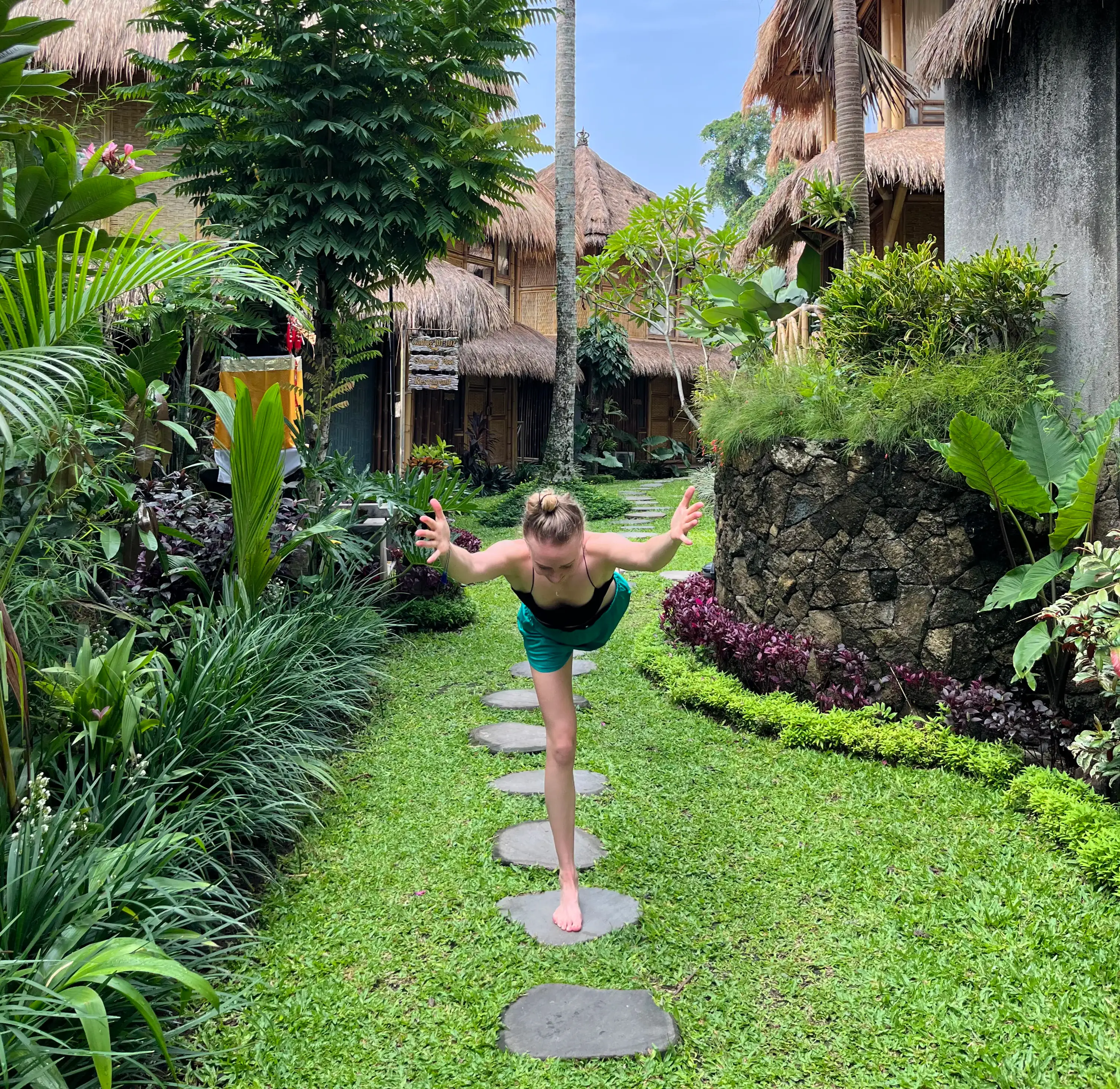 Girl in a yoga pose in a tropical landscape in Bali.